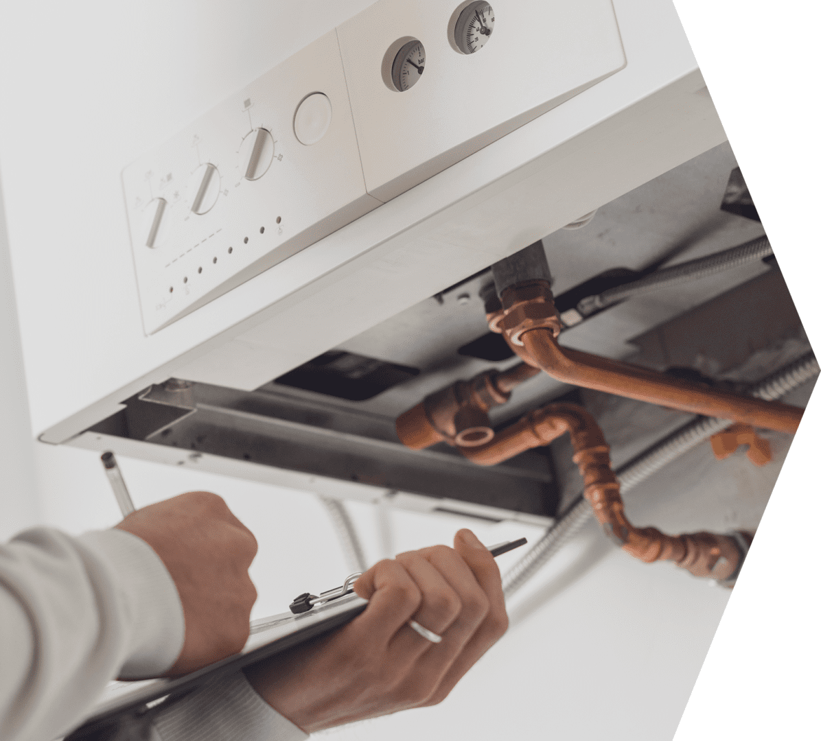 Professional plumber servicing a boiler and writing on a clipboard