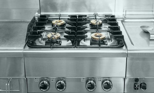 Image of the gas stove. Closeup modern gas stove on counter top in contemporary industrial kitchen.